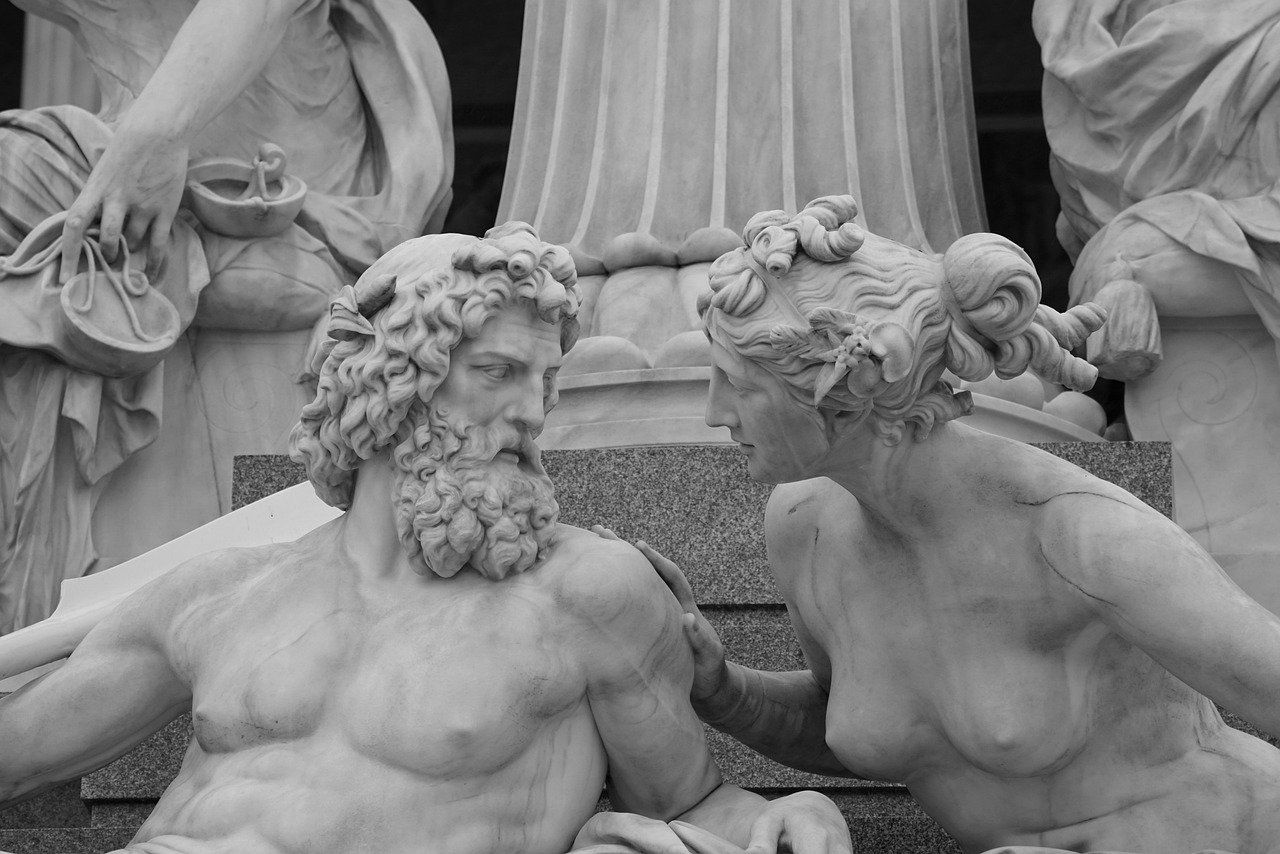 Estatua de 2 dioses desnudos conversando.